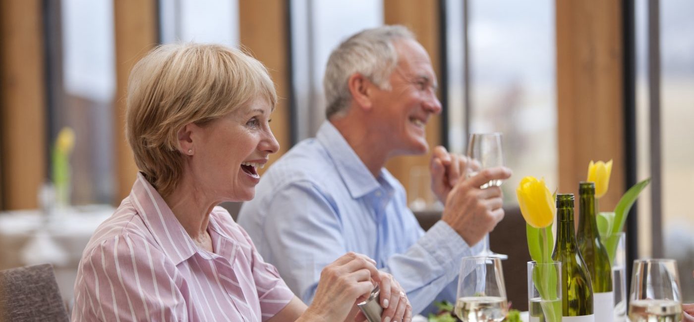 Retired senior couple enjoying meal at table in restaurant